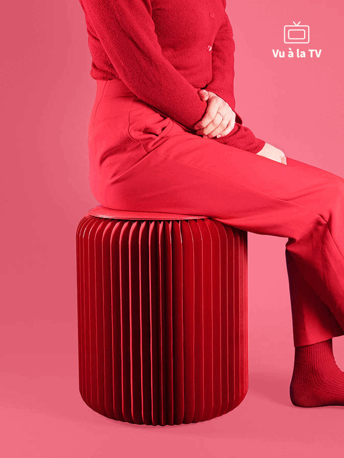 Femme assise sur un tabouret en carton