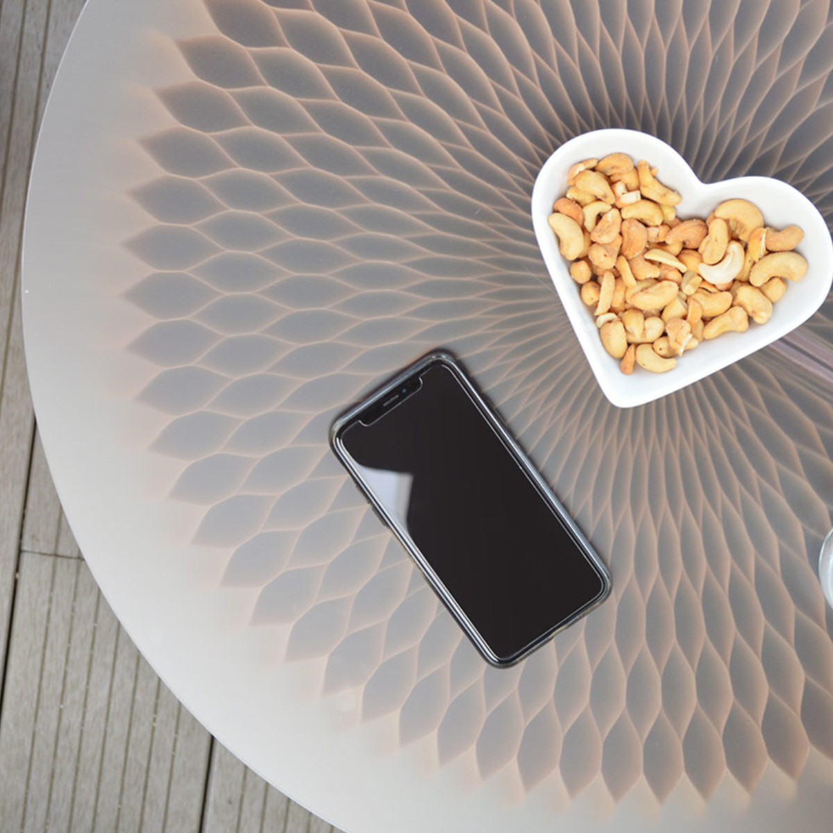 Téléphone et assiette sur la table basse en carton alvéolé et plateau en plexiglass.