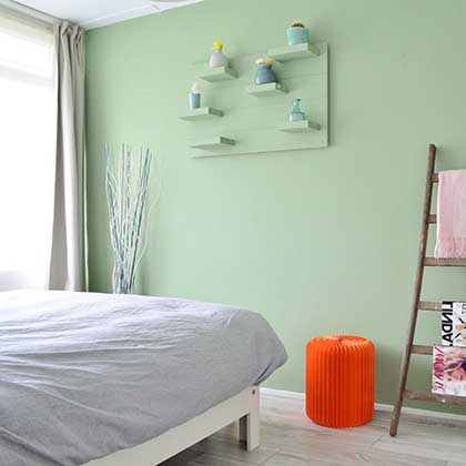 Le petit tabouret orange dans une chambre verte